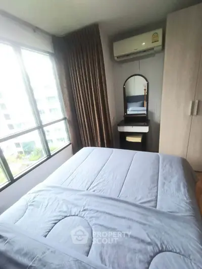 Cozy bedroom with large window and air conditioning in modern apartment.