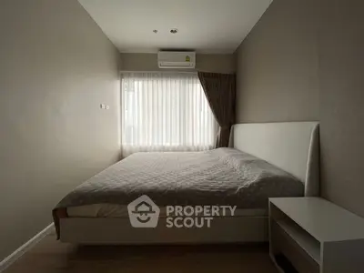 Cozy bedroom with modern decor and natural light, featuring a comfortable bed and air conditioning.