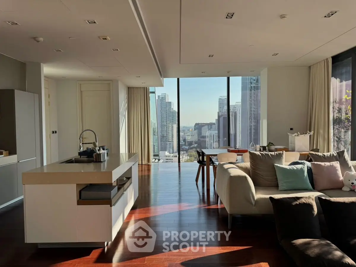 Luxurious open-layout living room with stunning city view and modern kitchen island.