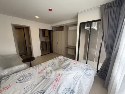 Modern bedroom with balcony access and stylish furnishings in a contemporary apartment.