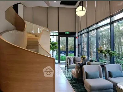 Luxurious modern living room with elegant staircase and large windows overlooking garden