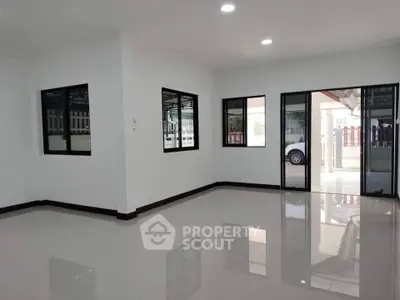 Spacious empty room with glossy tiled floor and large windows