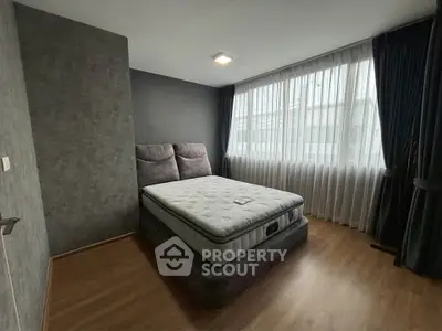 Spacious bedroom with large window and modern decor