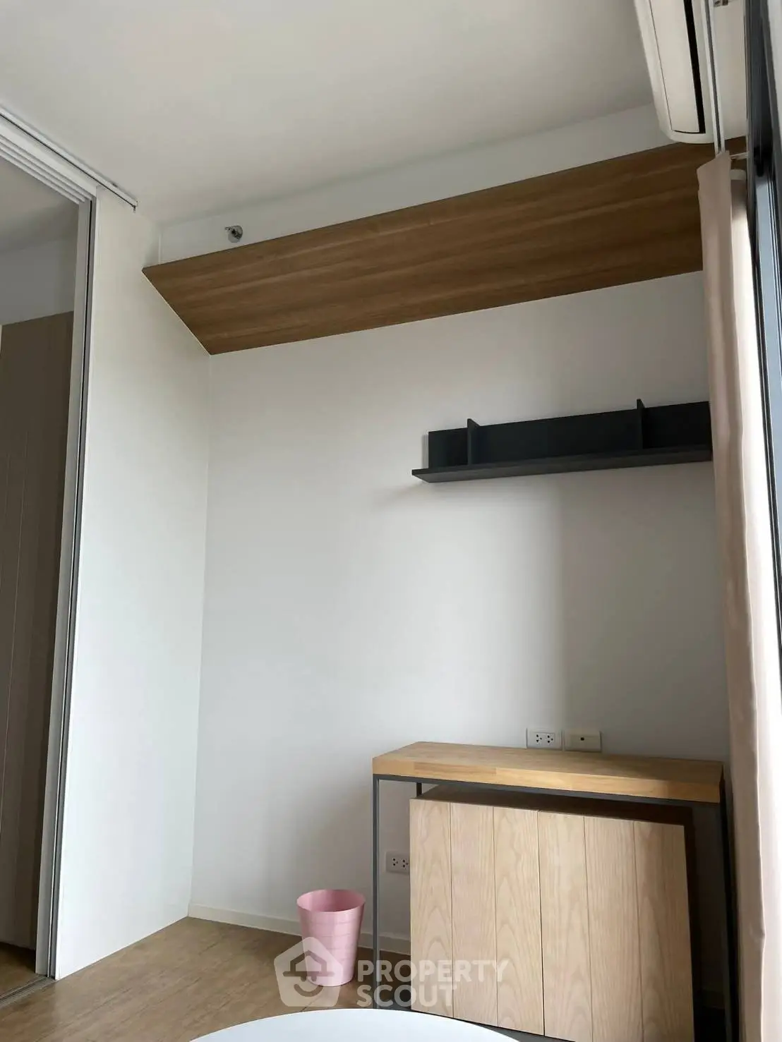 Modern minimalist study room with wooden desk and shelves, perfect for productivity and style.