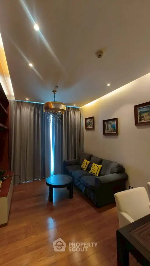Cozy living room with elegant lighting and wooden flooring, featuring a comfortable sofa and stylish decor.