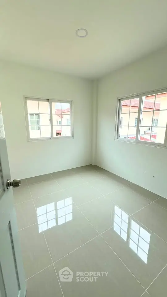 Bright empty room with tiled floor and large windows in modern home