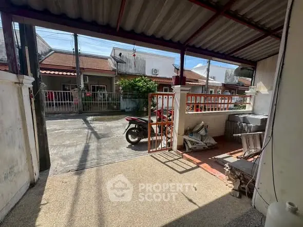 Charming residential street view with motorbike and gated entrance