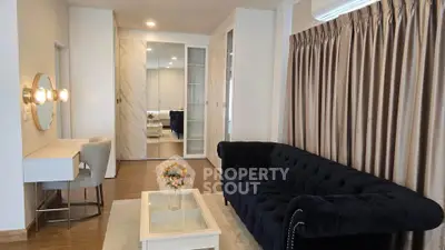 Elegant living room with plush navy sofa, chic vanity, and stylish decor