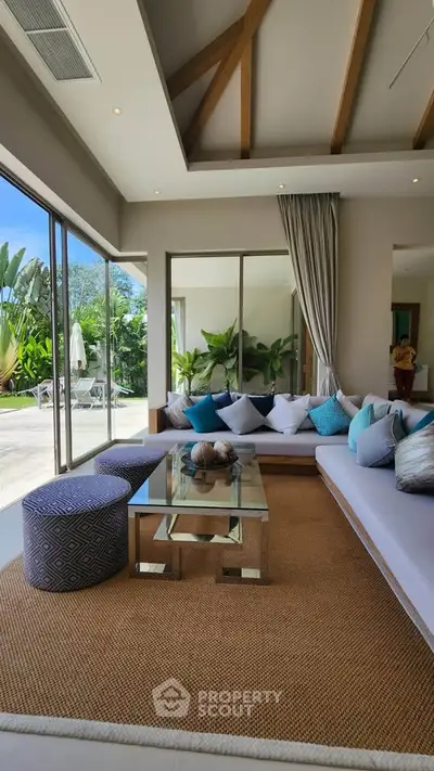 Luxurious living room with modern decor and large windows overlooking a lush garden.