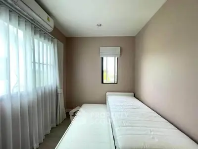 Bright bedroom with large window and air conditioning unit, featuring minimalistic design.
