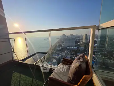 Stunning high-rise balcony with panoramic ocean and city views, perfect for relaxation and enjoying sunsets.