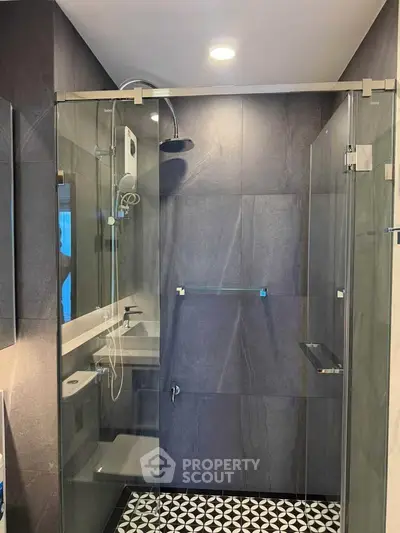 Modern bathroom with sleek glass shower enclosure and stylish tile flooring.