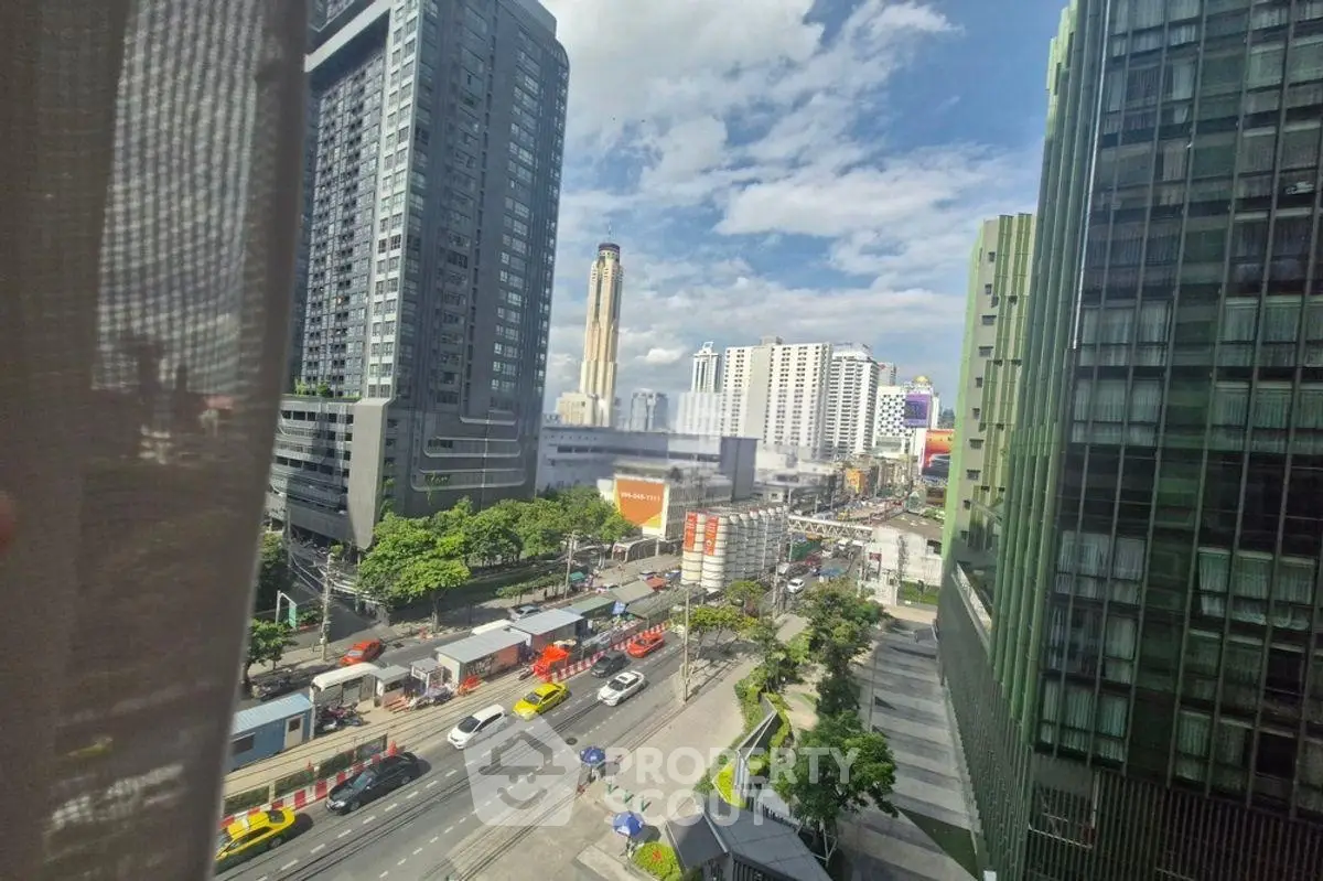 Stunning cityscape view from high-rise building window, showcasing urban skyline and bustling streets.