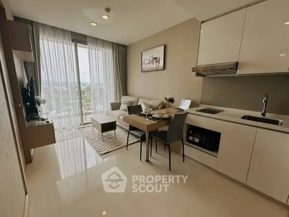 Modern open-layout living room with kitchen, featuring sleek design and natural light.