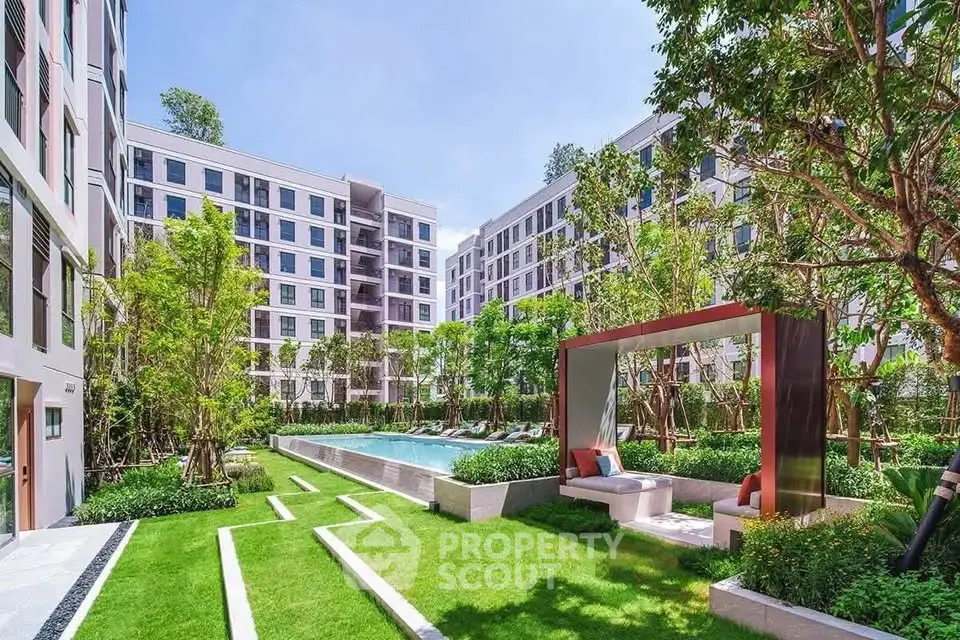 Luxurious apartment complex with lush garden and inviting pool area, perfect for relaxation and leisure.