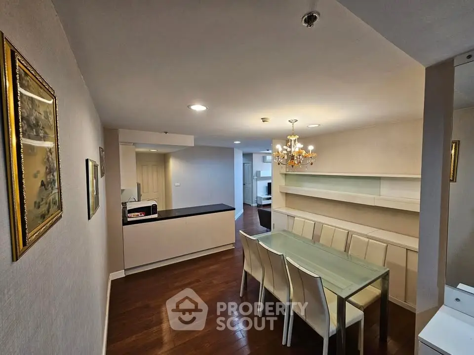 Spacious dining area with elegant chandelier and modern decor in a stylish apartment.