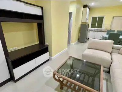 Spacious living room with modern furniture and open kitchen layout in a cozy apartment.