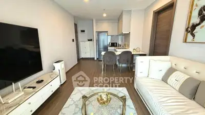 Modern living room with open kitchen, stylish decor, and sleek furniture in a contemporary apartment.