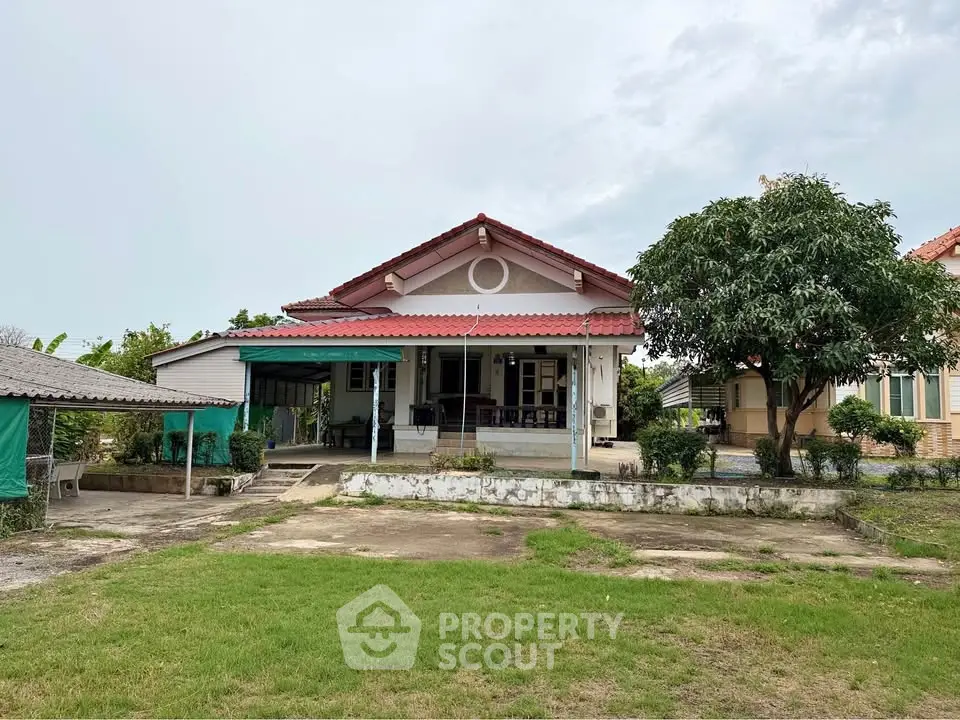 Charming single-story house with spacious front yard and lush greenery, perfect for family living.