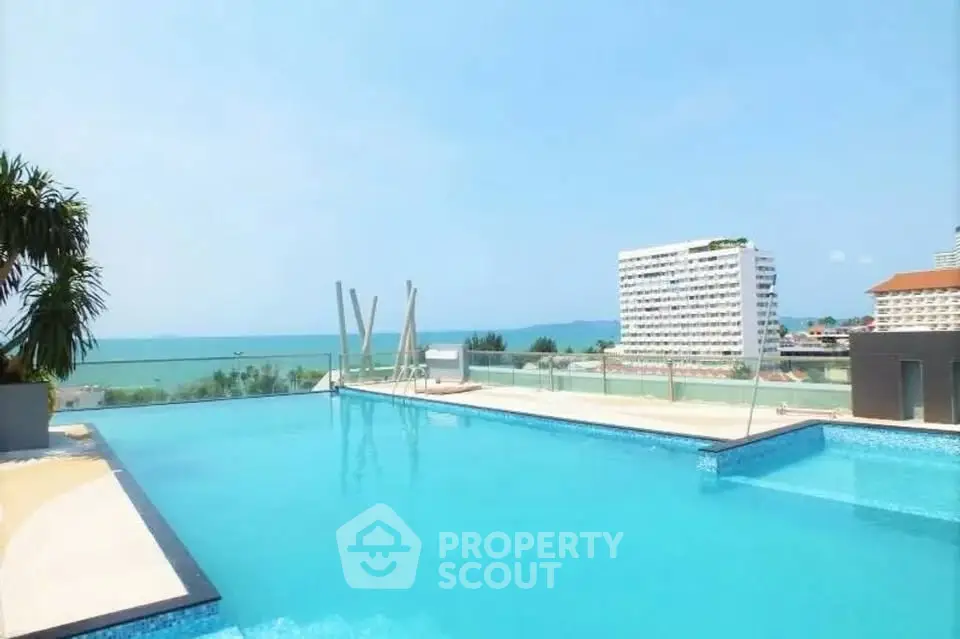 Stunning rooftop pool with panoramic ocean views in luxury high-rise building.