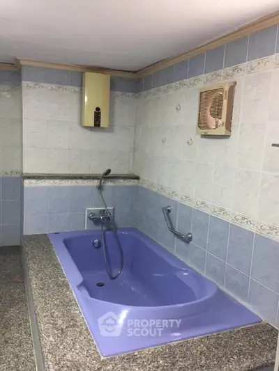 Spacious bathroom with unique blue bathtub and modern fixtures