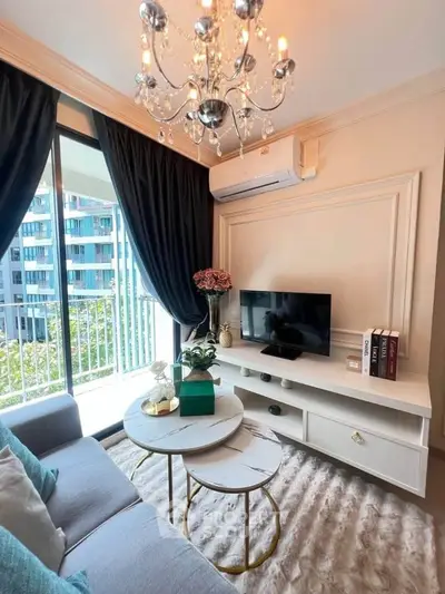 Elegant living room with chandelier, balcony view, and modern decor