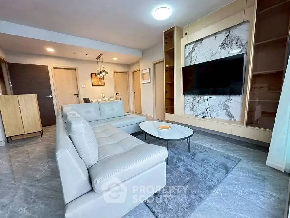 Modern living room with sleek furniture and marble accent wall, perfect for stylish urban living.