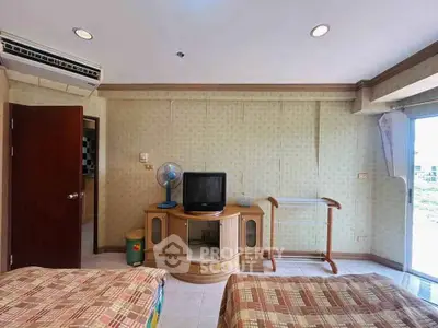 Cozy bedroom with vintage decor and natural light, featuring a TV and air conditioning.