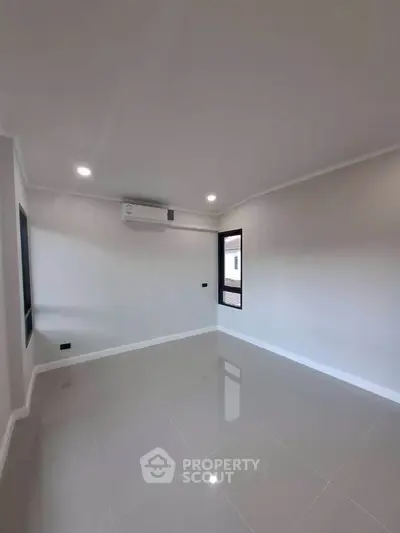 Spacious unfurnished room with sleek tile flooring and modern air conditioning unit.