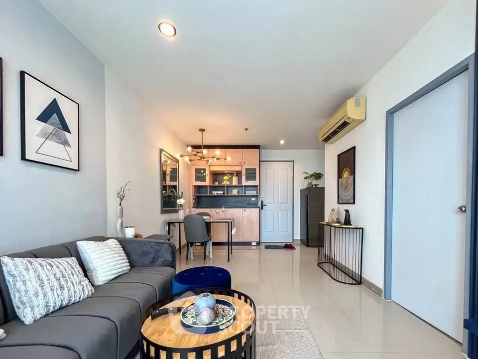 Modern living room with stylish decor and open layout, featuring cozy seating and elegant lighting.