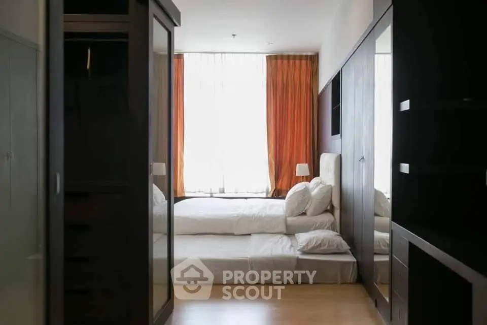 Spacious bedroom with modern furnishings and large windows for natural light.