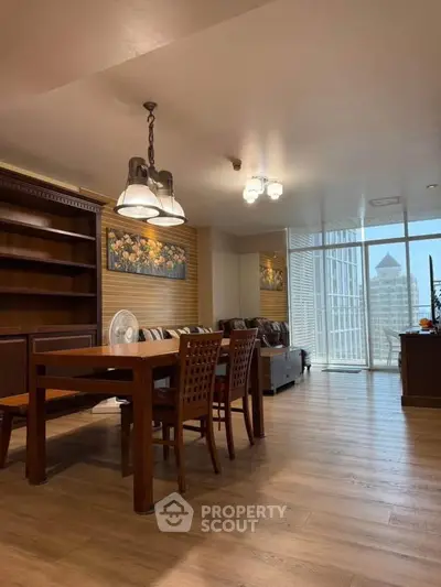 Spacious living room with elegant wooden furniture and city view balcony