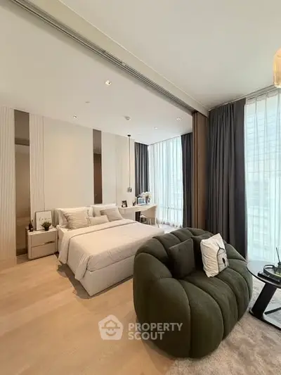 Luxurious modern bedroom with stylish furniture and large windows offering natural light.