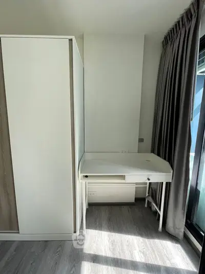 Modern study area with sleek desk and wardrobe in bright room