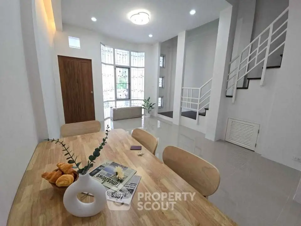 Spacious modern living room with elegant staircase and natural light