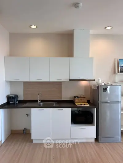 Modern kitchen with sleek white cabinets and stainless steel appliances