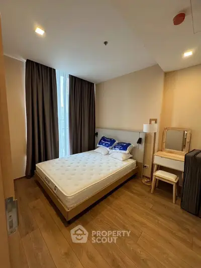 Cozy bedroom with wooden flooring and natural light