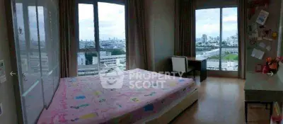 Spacious bedroom with large windows offering stunning city views, perfect for urban living.
