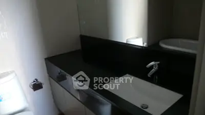 Modern bathroom with sleek black countertop and integrated sink