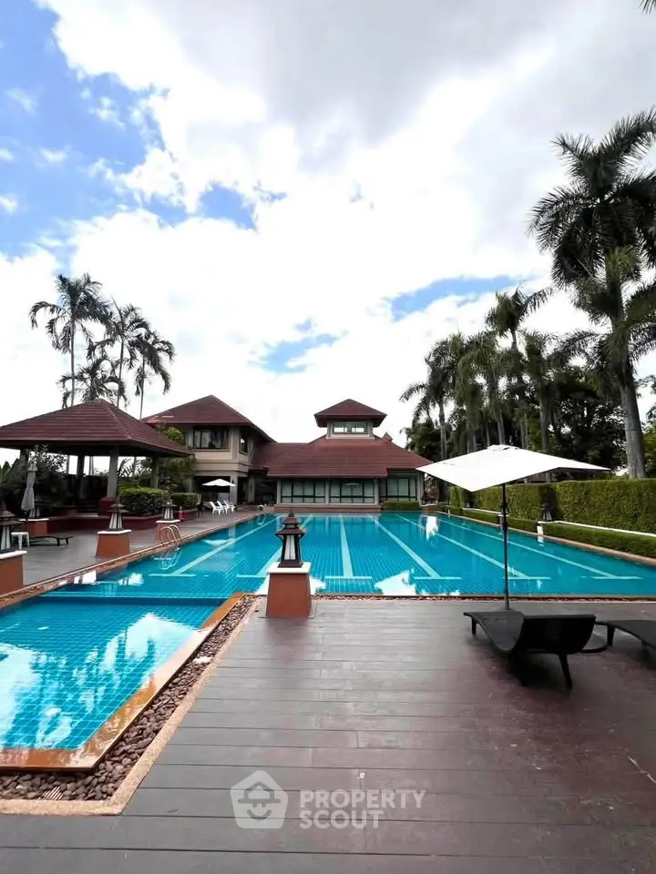 Luxurious outdoor pool area with tropical landscaping and elegant architecture, perfect for relaxation and leisure.