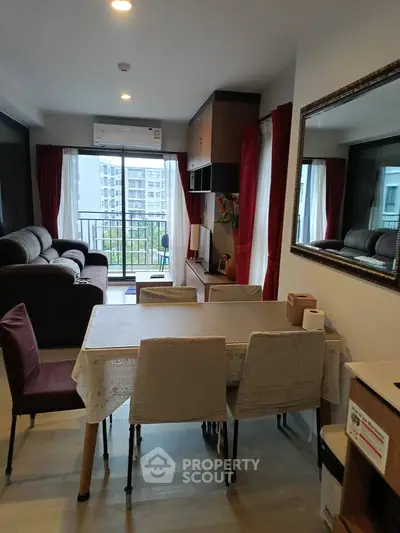Modern living room with dining area and balcony view in a stylish apartment.