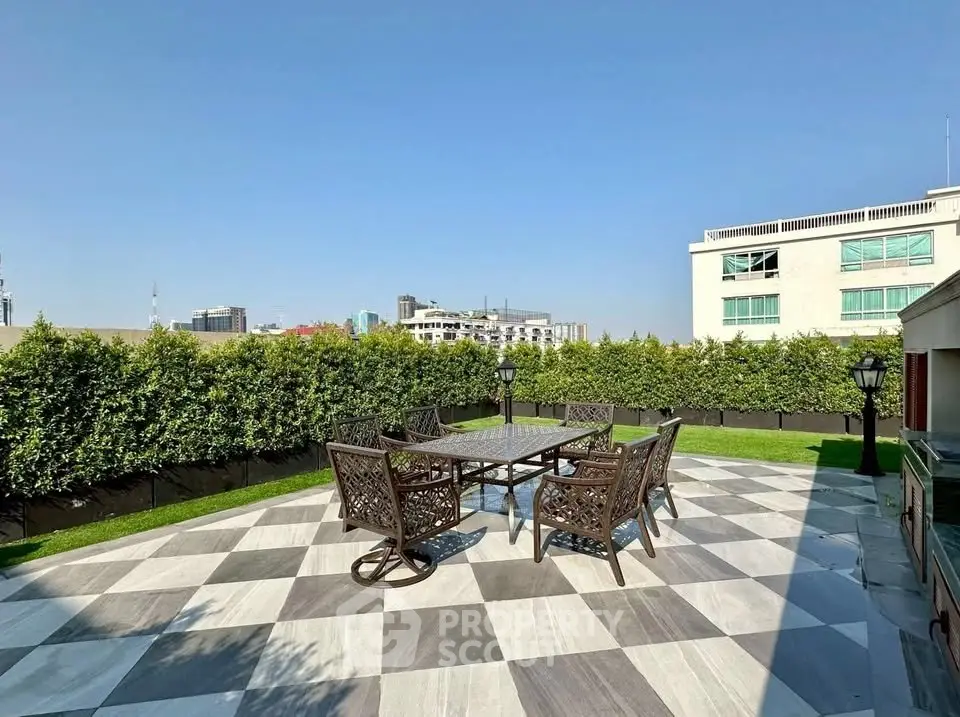 Spacious rooftop terrace with elegant outdoor furniture and city views, perfect for entertaining.