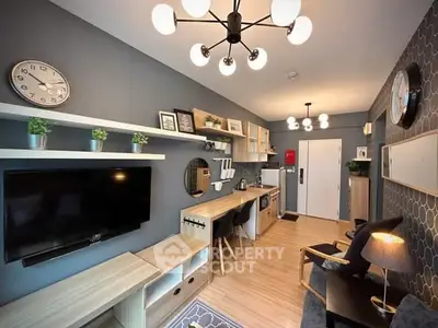 Modern living room with stylish decor and open kitchen layout, featuring sleek furniture and contemporary lighting.