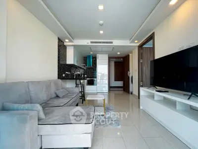 Modern living room with open kitchen, sleek design, and cozy sofa in a stylish apartment.