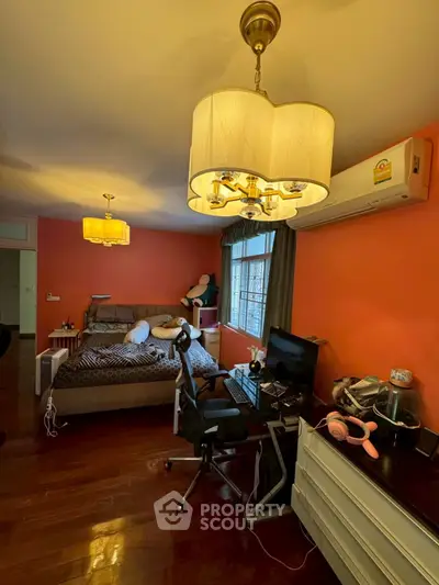 Cozy bedroom with modern lighting, workspace, and air conditioning, perfect for comfort and productivity.