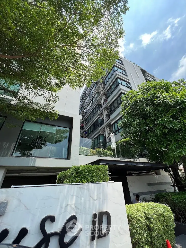 Modern apartment building with lush greenery and clear blue sky