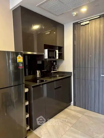 Modern compact kitchen with sleek cabinets and stainless steel appliances in urban apartment.