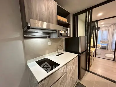 Modern compact kitchen with sleek design and integrated appliances in a stylish apartment.