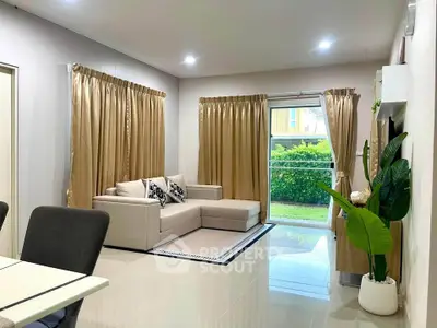 Spacious living room with modern decor and garden view, featuring a cozy sectional sofa and elegant curtains.