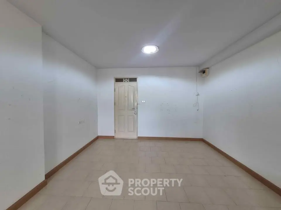 Spacious empty room with tiled flooring and white walls, ideal for customization.